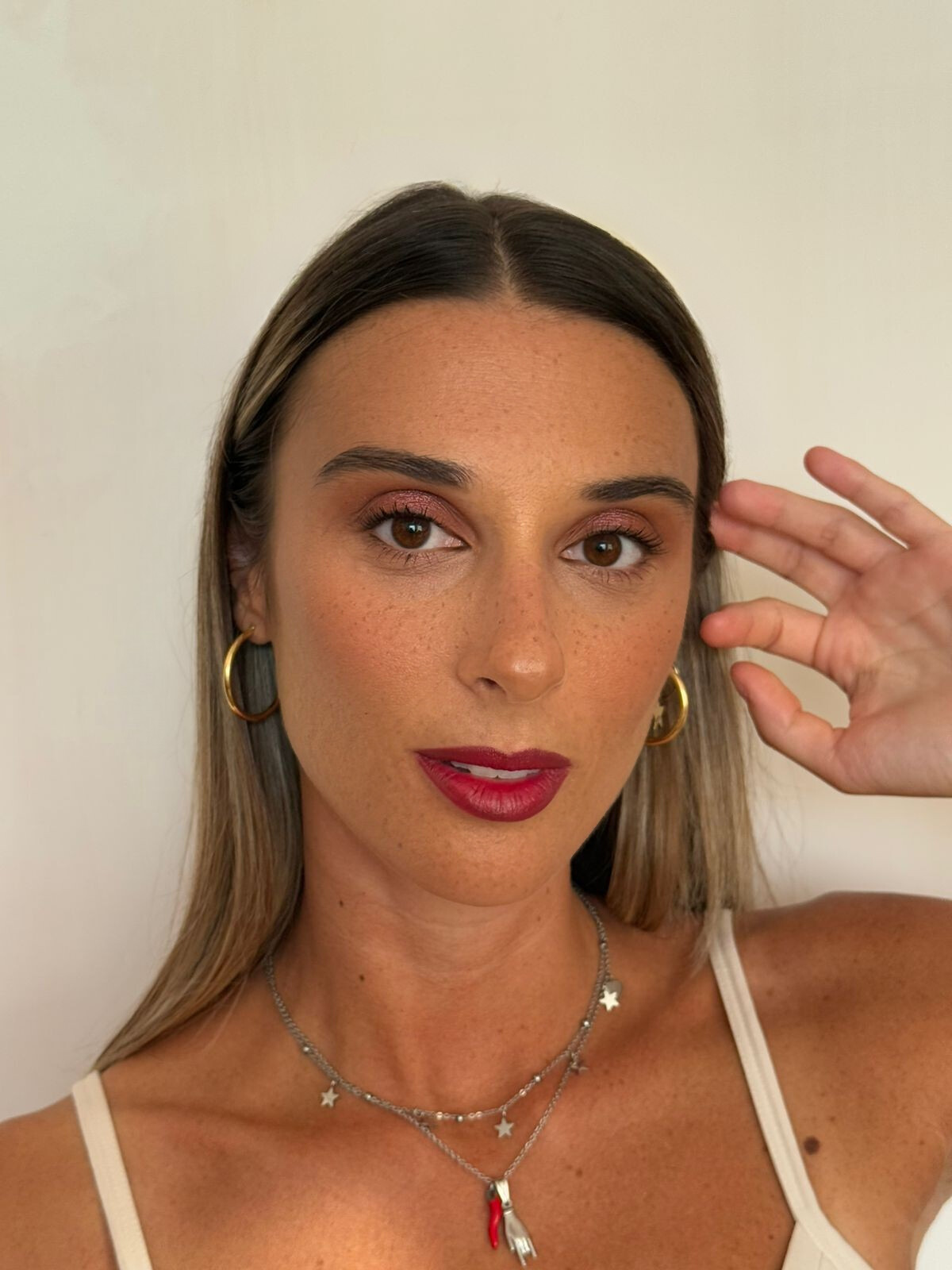 A glowing look with warm-toned eyeshadow, natural skin with freckles in focus, and bold berry lips that add a touch of sophistication.